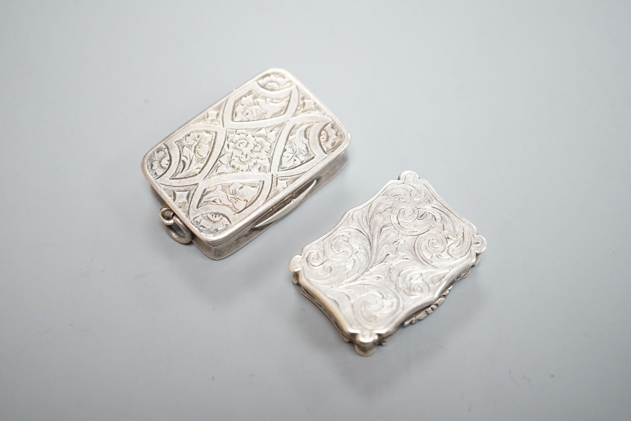 An early Victorian engraved silver shaped rectangular vinaigrette, by Nathaniel Mills, Birmingham, 1844, 31mm and a later silver vinaigrette by George Unite.